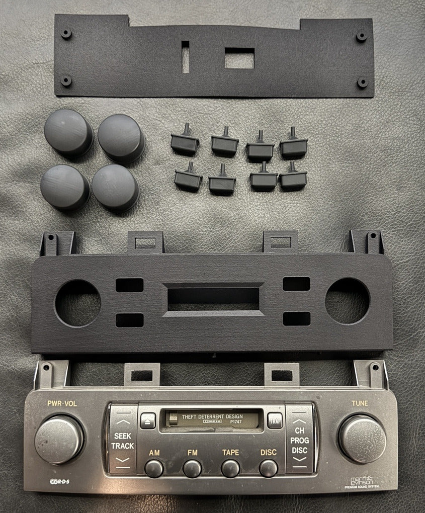 HVAC faceplate, rotary knobs and button prototypes arranged beside factory trim.